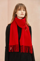 Raving Red solid merino scarf draped long over a black outfit, front view