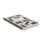 Angled view of the cat-patterned softcover journal lying closed