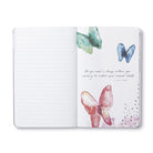 Open journal with lined pages beside a page of small watercolour butterflies and a quote