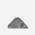 Corner close-up of the metallic silver pouch zip and clip