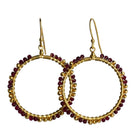 Overlapping gold hoop earrings wire-wrapped with wine-red ruby beads