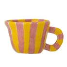 Stoneware cup with rose pink and yellow vertical stripes, a flared rim and a striped handle