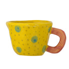 Yellow stoneware cup with teal spots and small green flecks, a flared rim and a coral handle