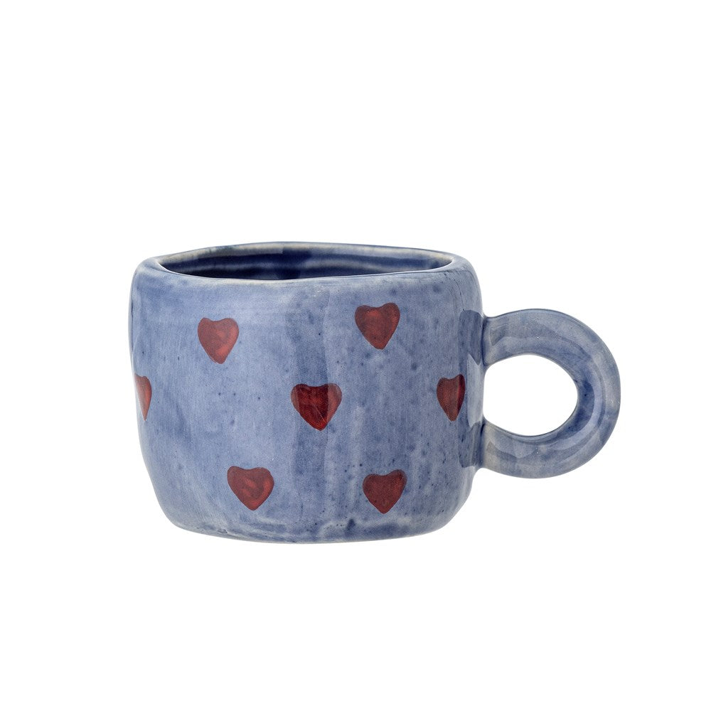 Periwinkle blue stoneware cup painted with small red hearts, with a round blue handle