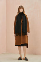 Full-length side view with the Ebony scarf over a camel coat