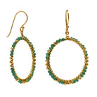 Gold hoop earrings wire-wrapped with emerald-green onyx beads, one hoop tilted