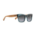Morgan sunglasses at an angle: a squared indigo blue frame with pale grained wood arms and grey lenses