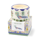 The peacock candle sitting on its Misted Lime gift box, printed with peacocks, urns and flowers.