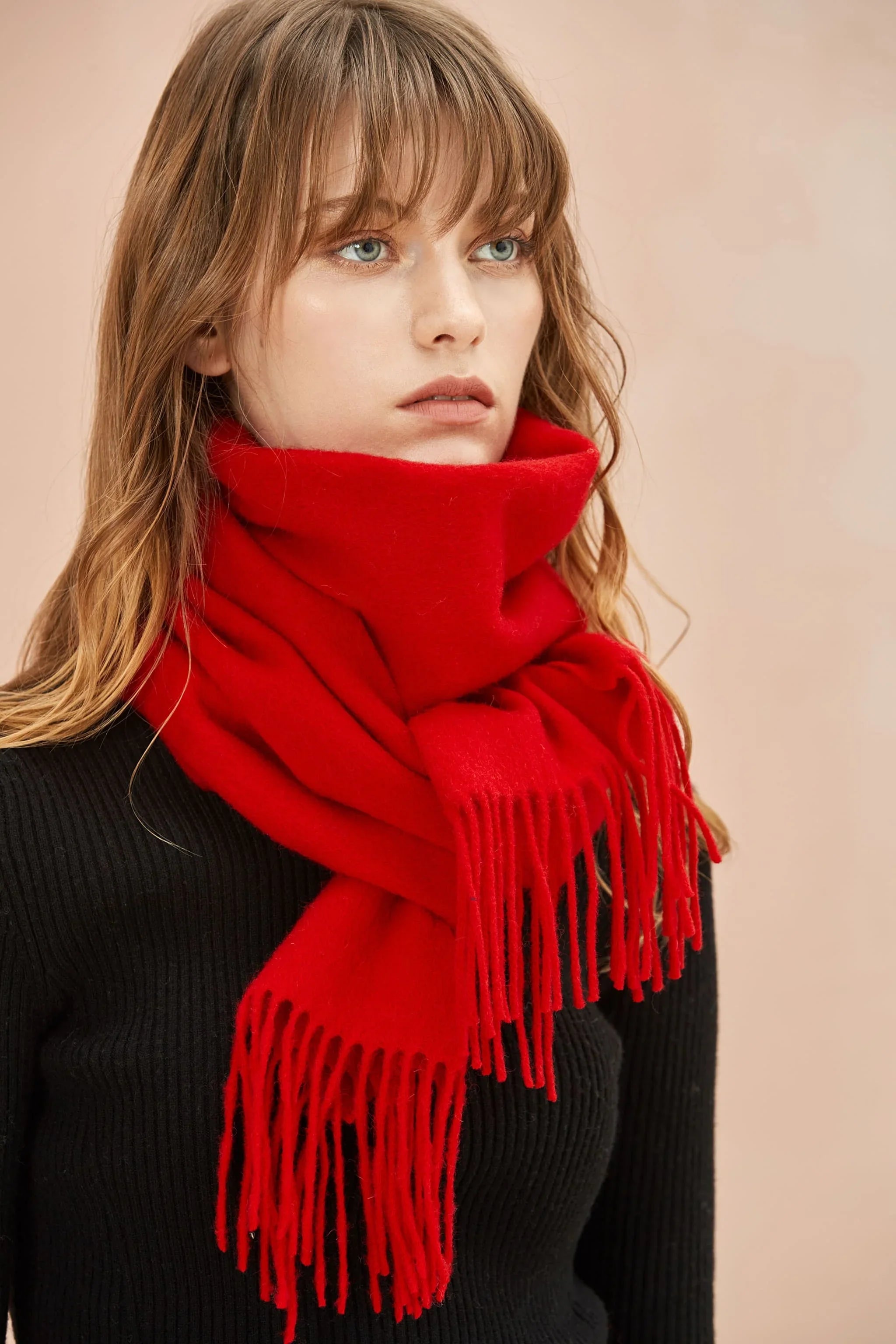 Model in black wearing the Raving Red merino scarf wrapped high at the neck