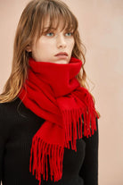 Model in black wearing the Raving Red merino scarf wrapped high at the neck