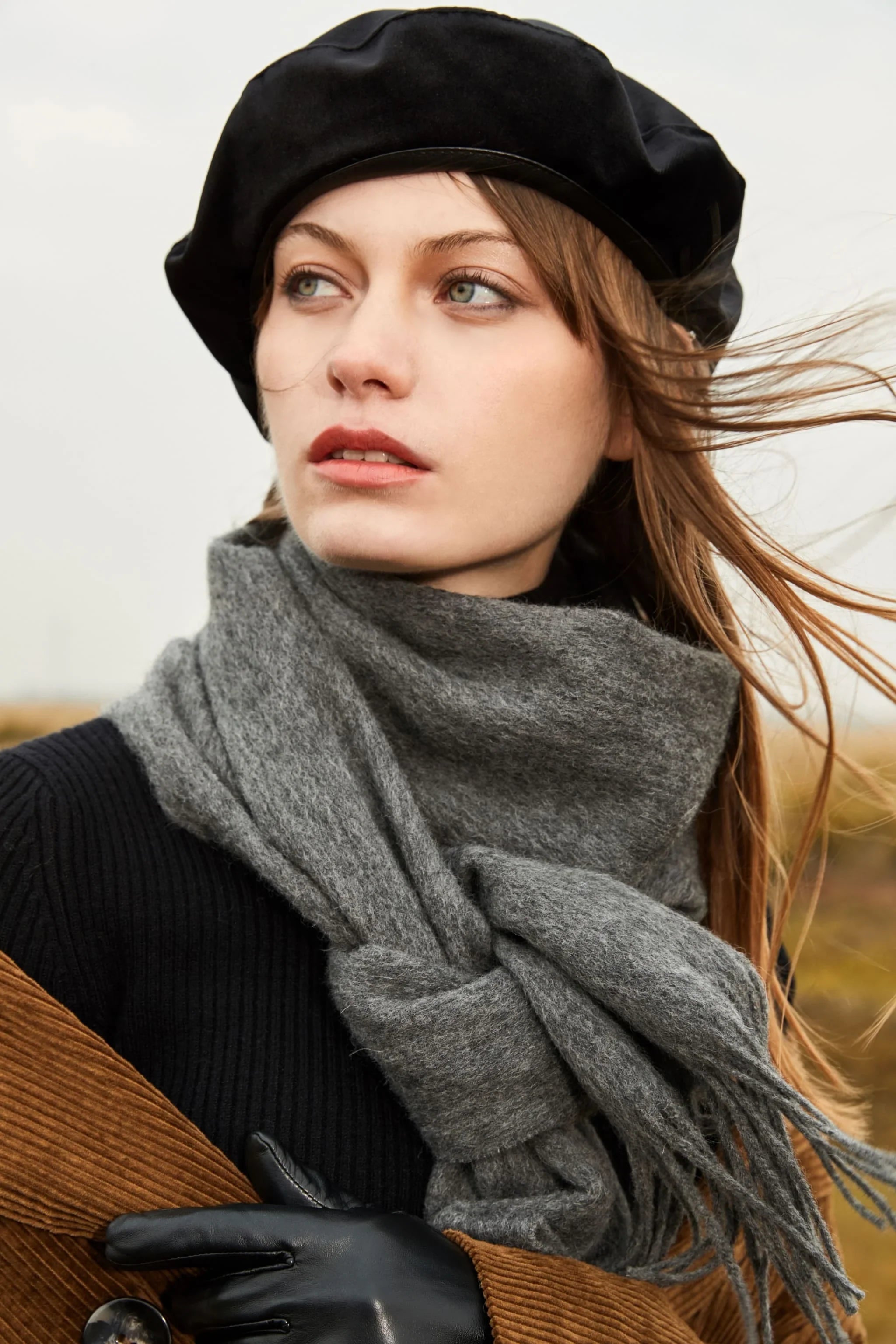 Model in a black beret wearing the Light Charcoal grey merino scarf knotted at the front