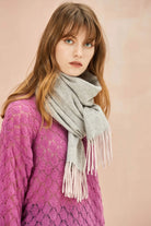 Model in a magenta jumper wearing the Quartz Pink scarf in grey with blush fringe