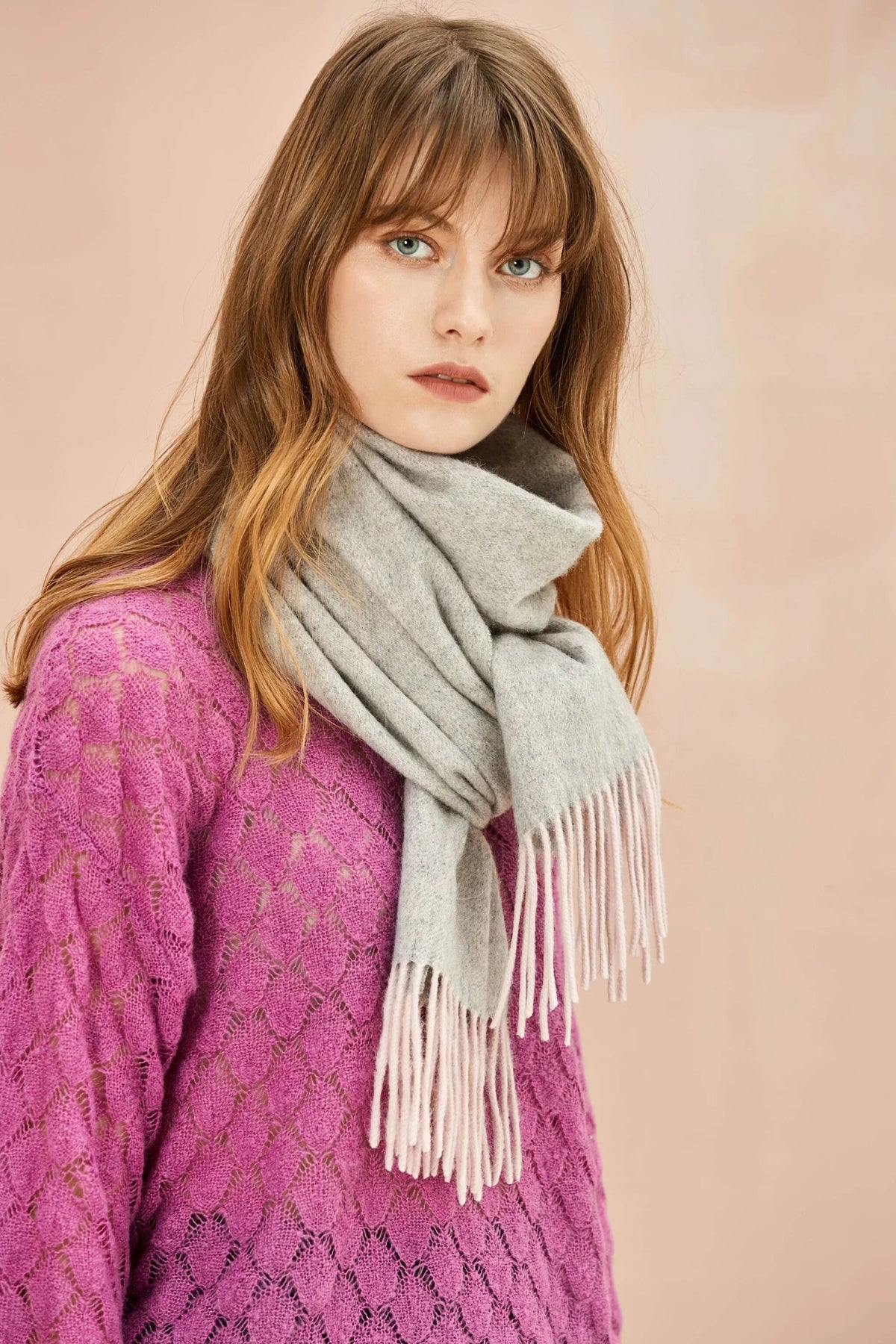 Model in a magenta jumper wearing the Quartz Pink scarf in grey with blush fringe