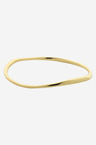 Soft gold bangle with an organic wave shape and a smooth polished finish.