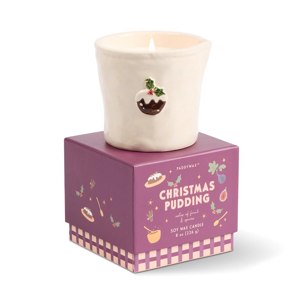 The Christmas pudding candle sitting on top of its closed plum gift box.