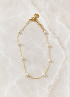 Fine gold chain bracelet with small white freshwater pearls spaced along its length