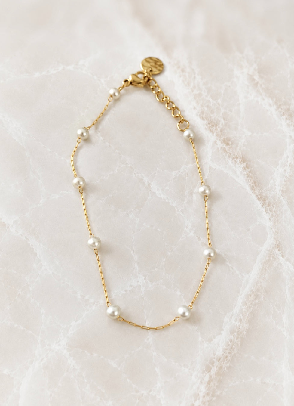 Fine gold chain bracelet with small white freshwater pearls spaced along its length