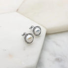 Silver freshwater pearl swirl clip-on earrings angled to show the clip fastening