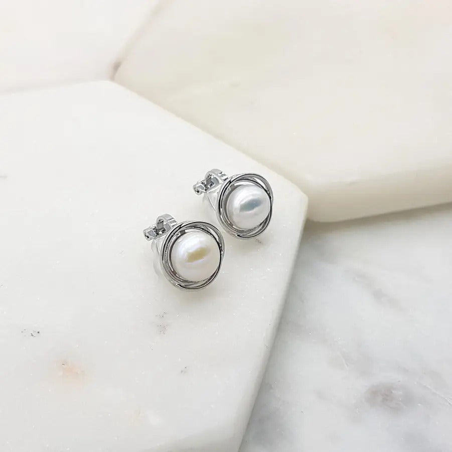 Silver freshwater pearl swirl clip-on earrings angled to show the clip fastening