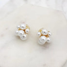 Pearl cluster clip-on earrings close up on a marble tile
