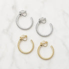 Crystal hoop clip-on earrings in silver and gold, two pairs on a white background