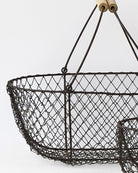 Close view of the woven wire mesh and wooden handle grips on the potager basket