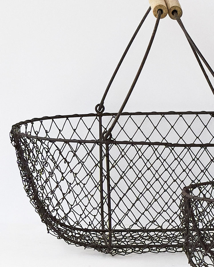 Close view of the woven wire mesh and wooden handle grips on the potager basket