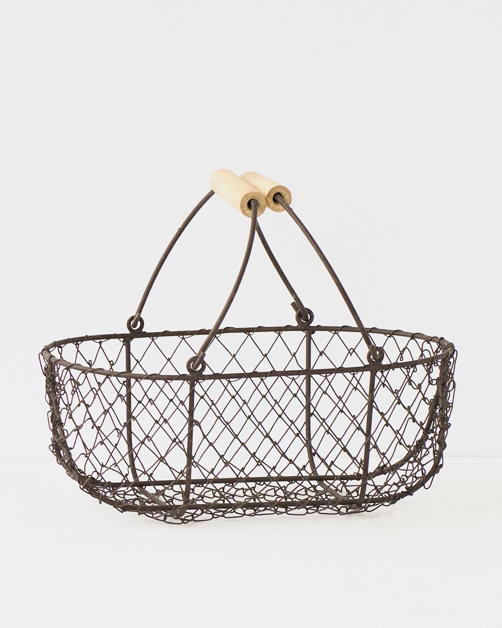 Small French potager wire basket with its folding handles raised