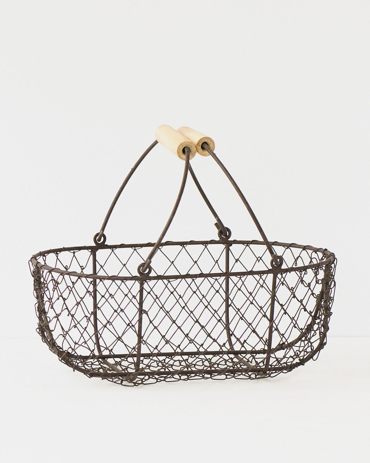 Small French potager wire basket with its folding handles raised