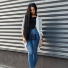 Woman in jeans and a cream cardigan wearing the navy phone pouch crossbody