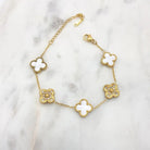 Gold-tone bracelet alternating white four-leaf clovers with pavé cubic zirconia clovers, on marble