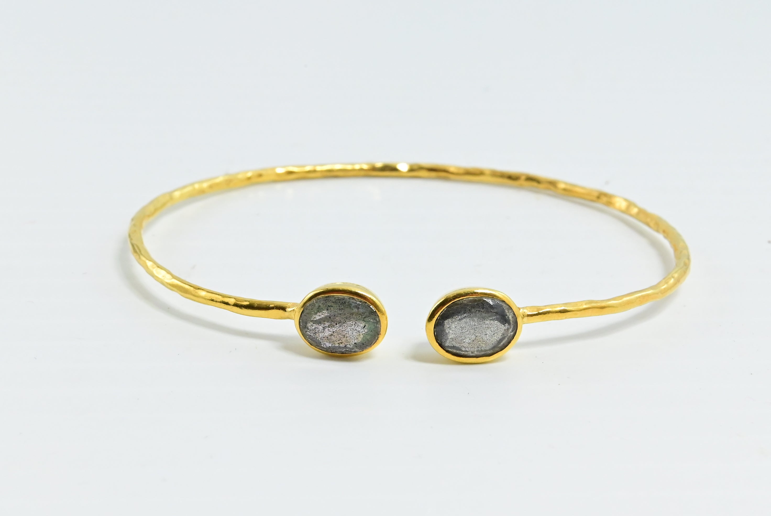 Close view of hammered Euro Gold cuff bangle with two grey oval gems