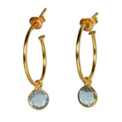 Euro Gold hoop earrings with a faceted blue topaz drop