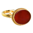 Gold ring with a smooth oval deep red carnelian in a beaded bezel