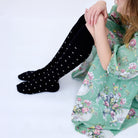 Close view of the black dotted knee socks with a green floral dress