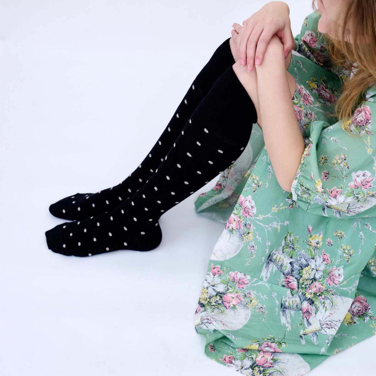 Close view of the black dotted knee socks with a green floral dress