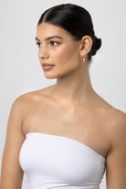 Model with her hair back wearing the Chelsea gold ball earring.