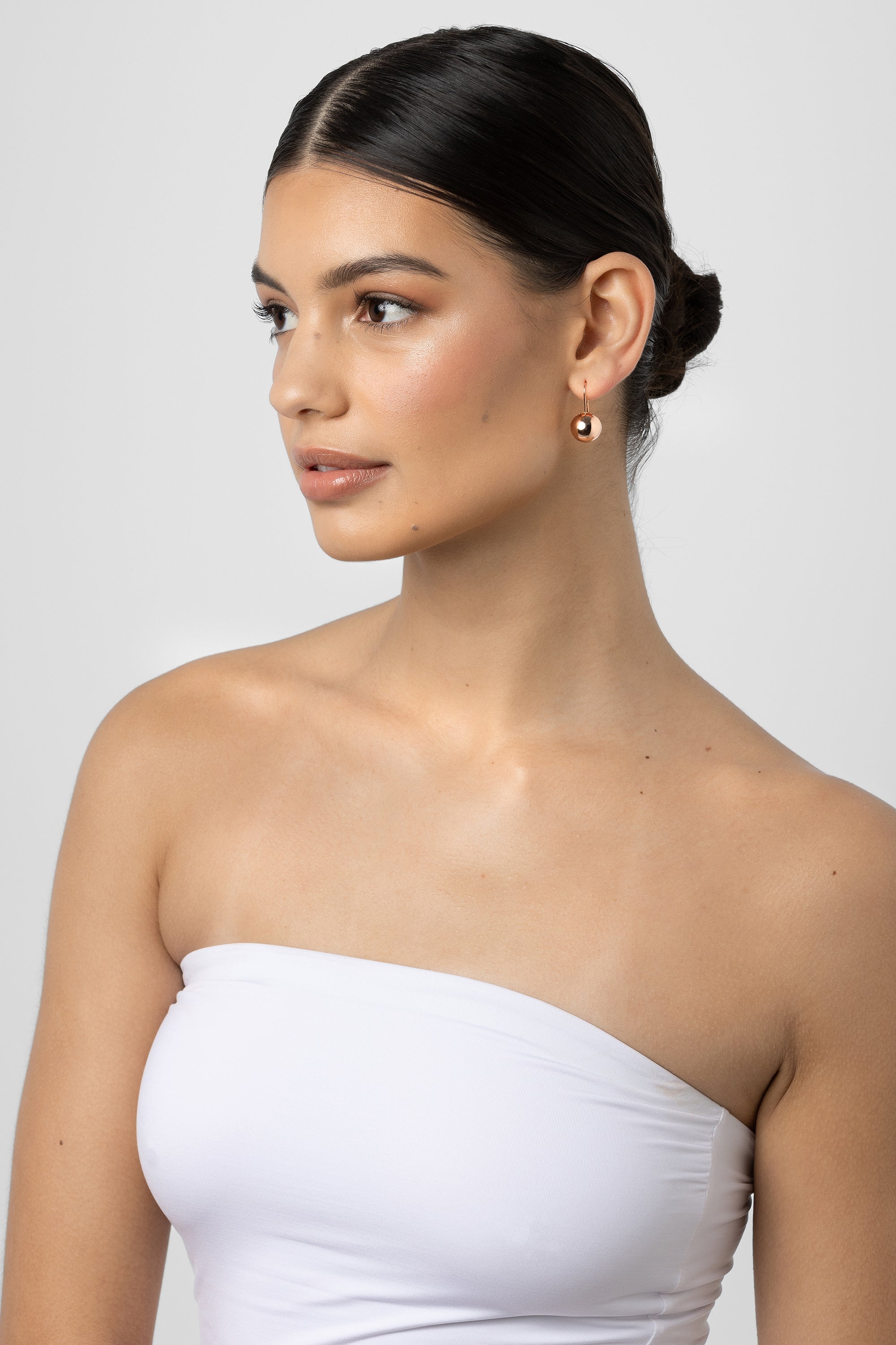 Model with her hair back wearing the Chelsea gold ball earring.