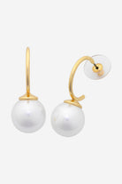 Gold curved hoop earrings, each finished with a large white shell pearl.