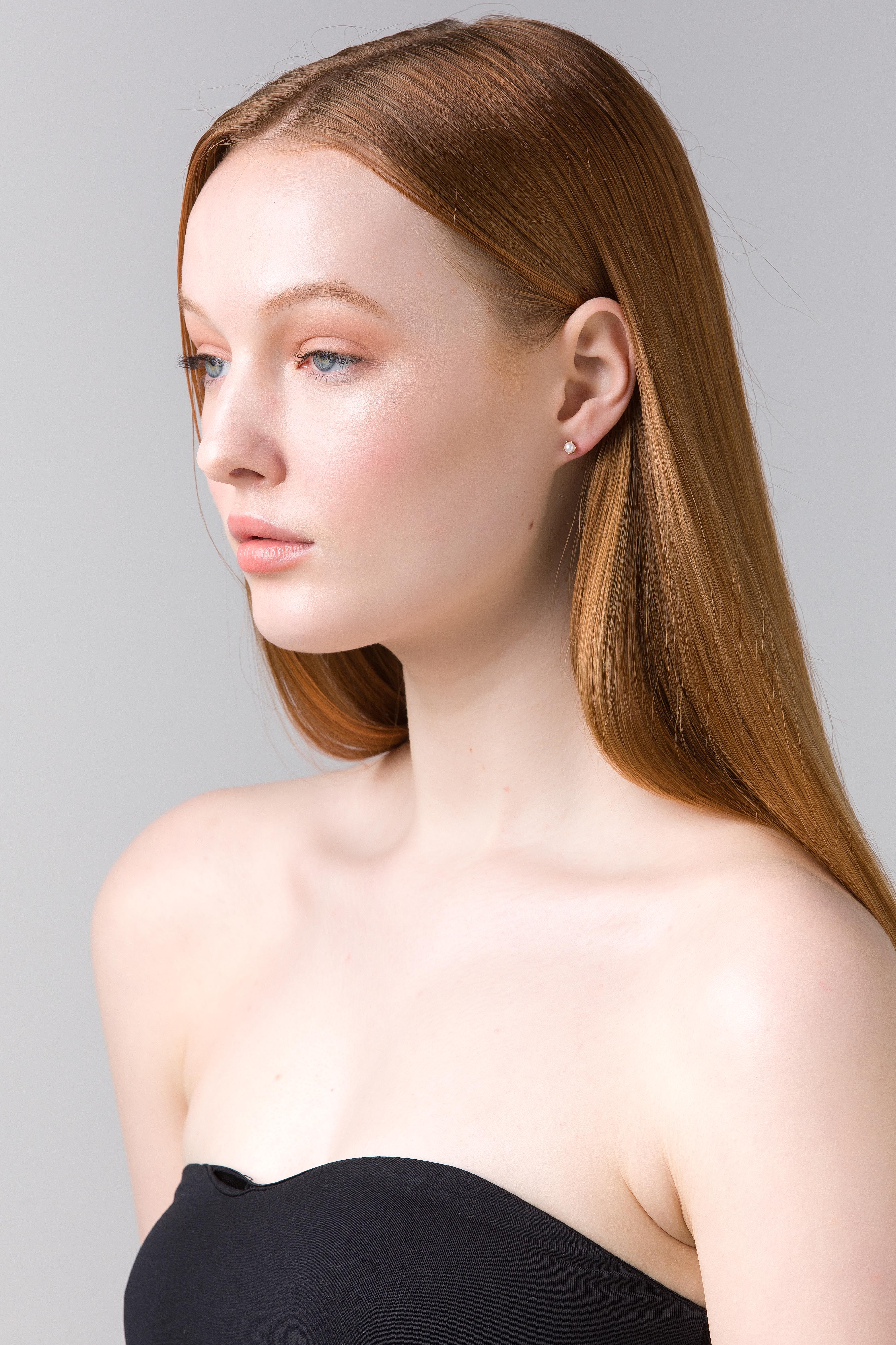 Model in profile wearing the Alia gold pearl studs.