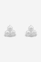 Silver stud earrings, each a small trio of white pearls.