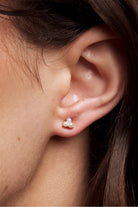 Close-up of a model's ear wearing the Petite Anya gold pearl trio stud.