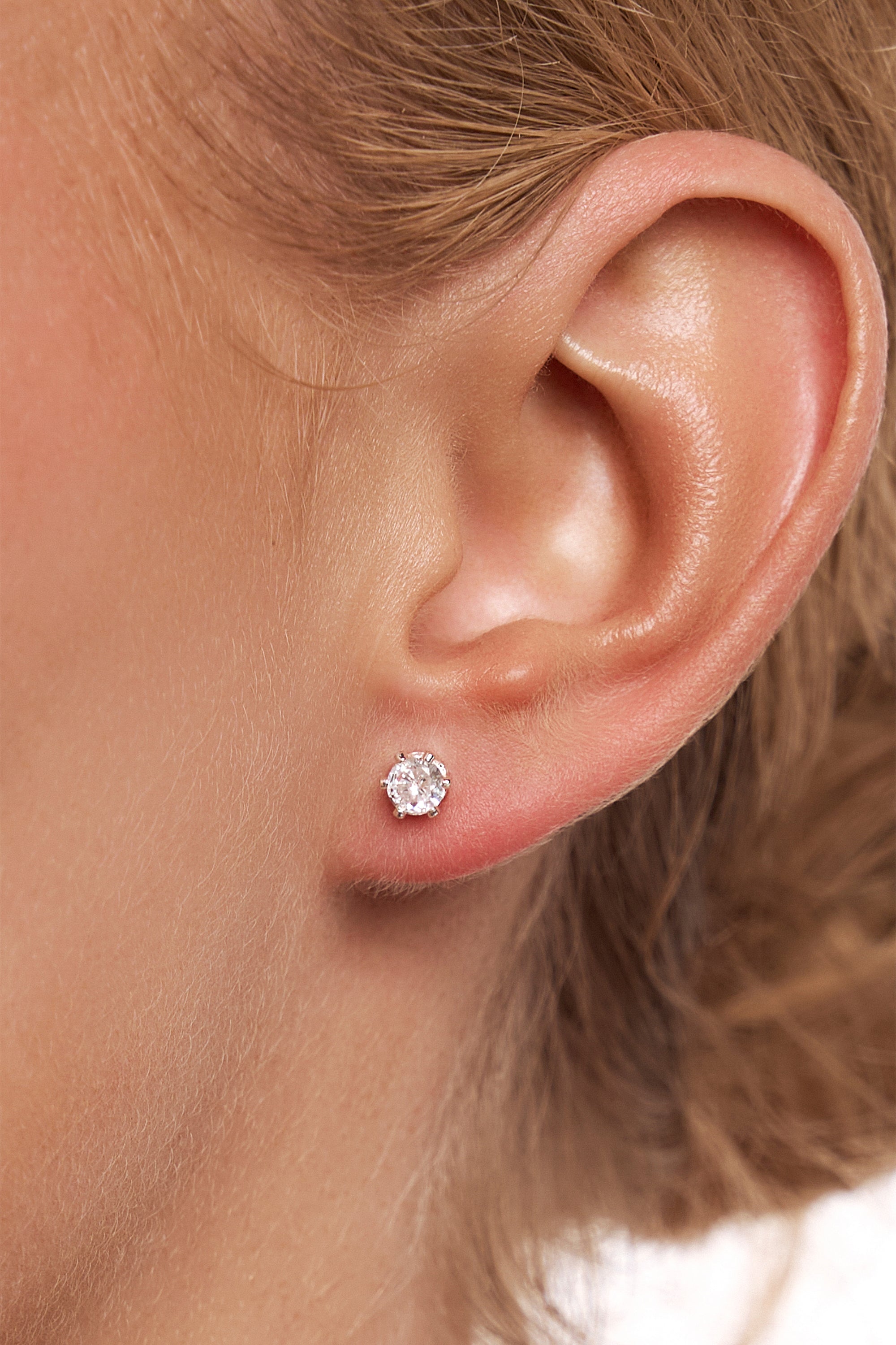Close-up of a model's ear wearing a Petite Tinkerbell silver crystal stud.