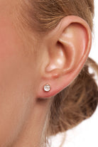 Close-up of a model's ear wearing a Petite Tinkerbell gold crystal stud.