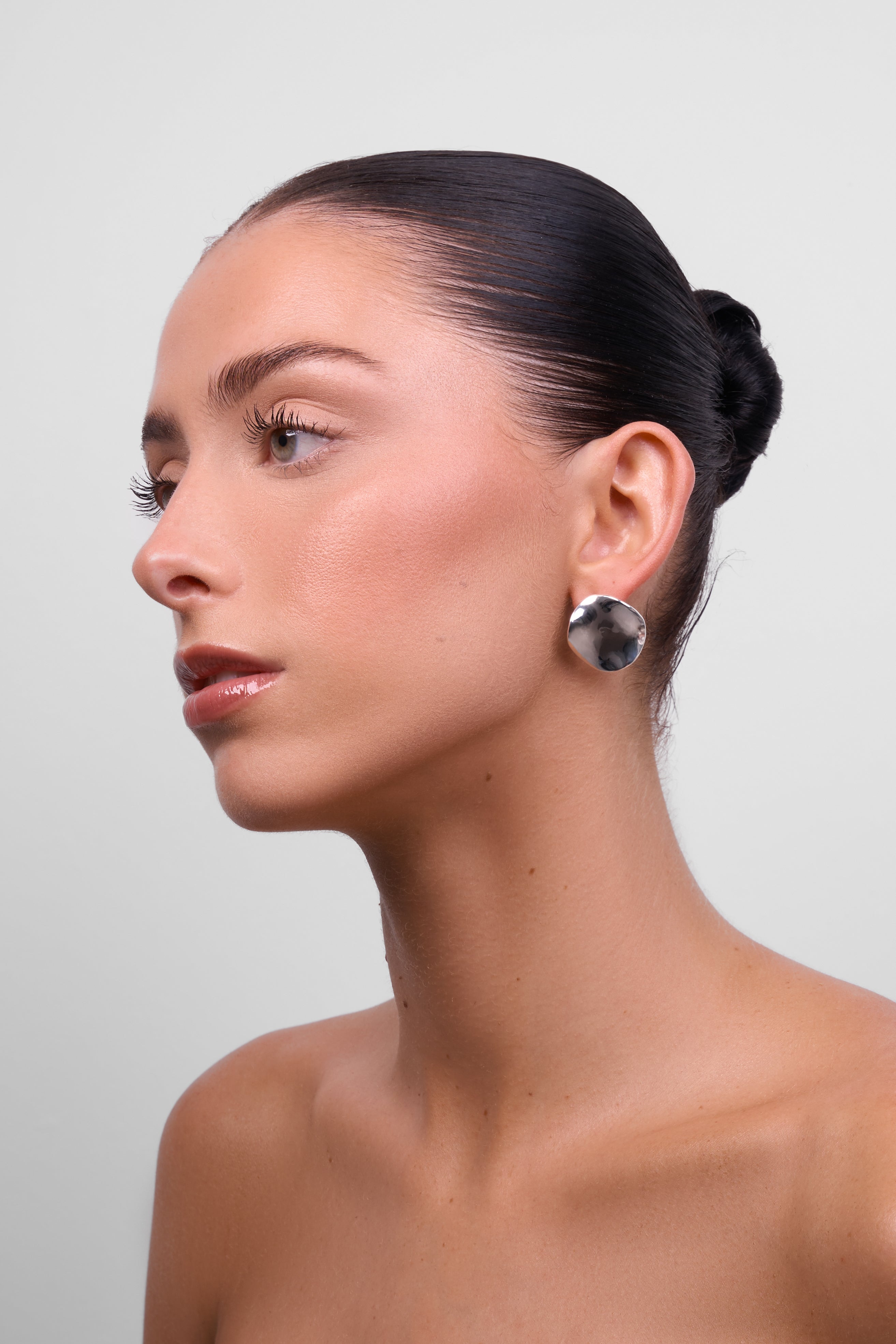 Model in profile wearing the Chloe silver organic-shape earring.