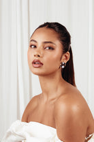 Model wearing the Chloe silver earrings, photographed against a pale curtain.