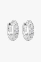 Silver huggie hoops set with a row of four small clear crystals.