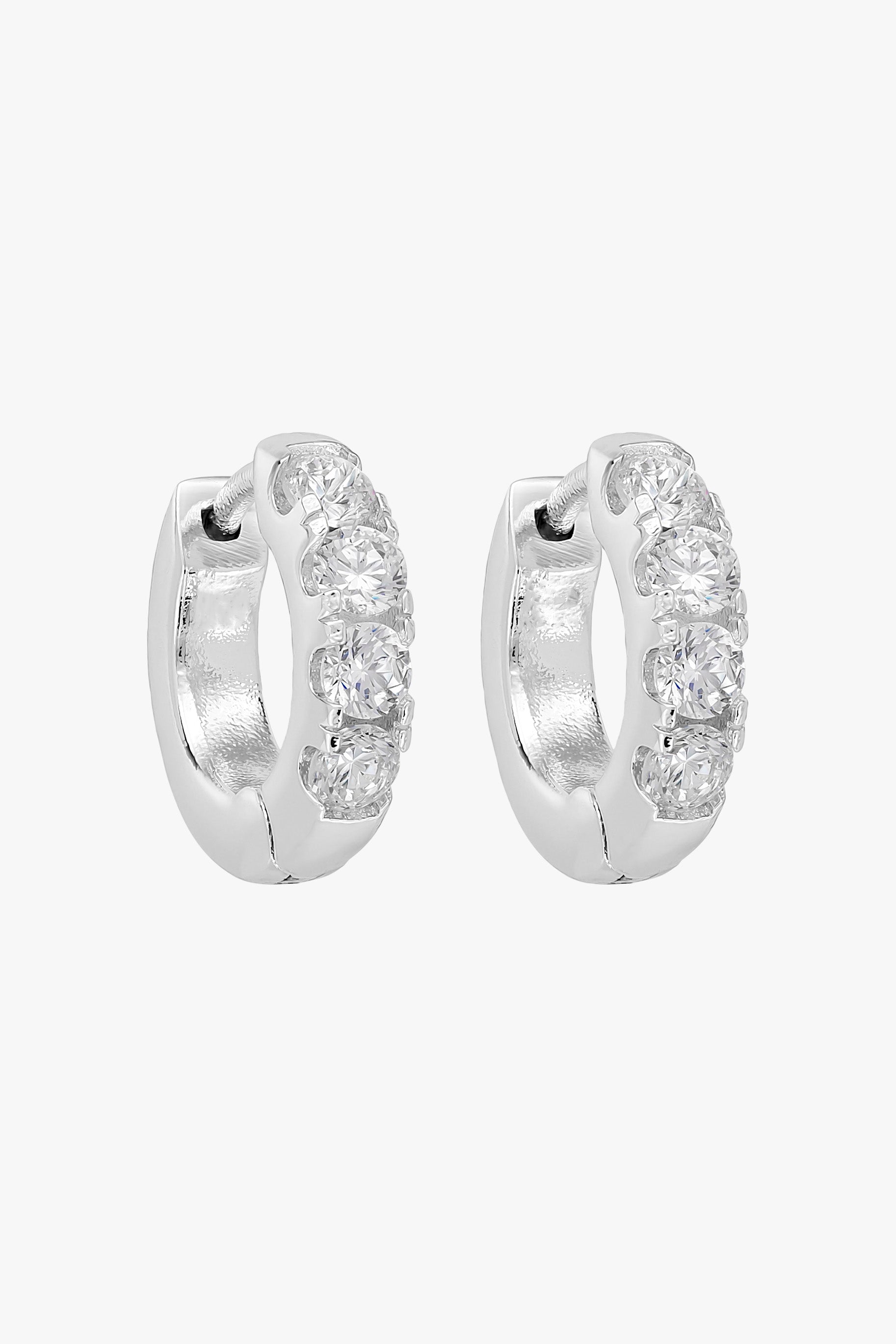 Silver huggie hoops set with a row of four small clear crystals.