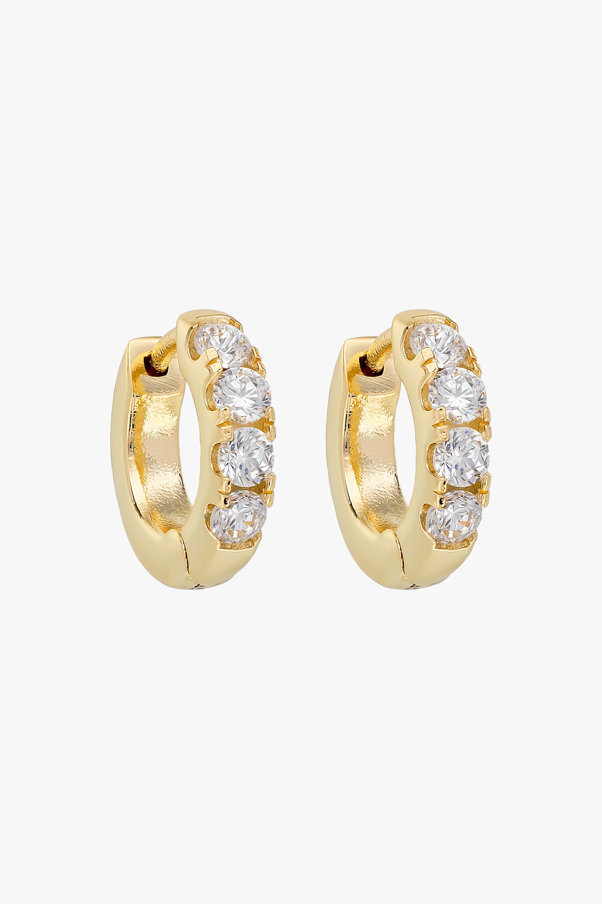 Gold huggie hoops set with a row of four small clear crystals.