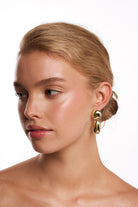 Model wearing the Malibu gold drop earring.